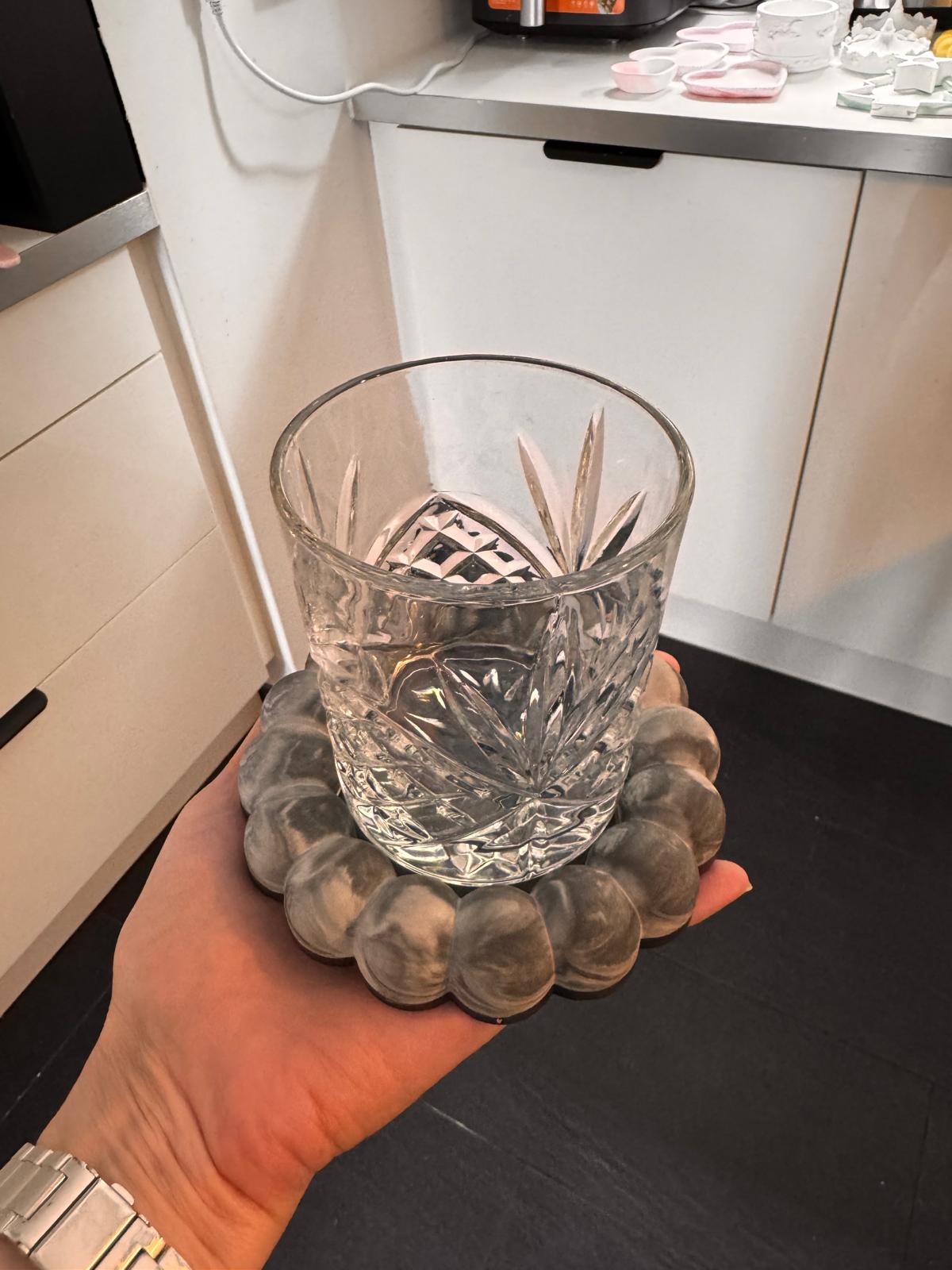 Grau marmorierte Bubble-Schale als Untersetzer für ein Kristallglas